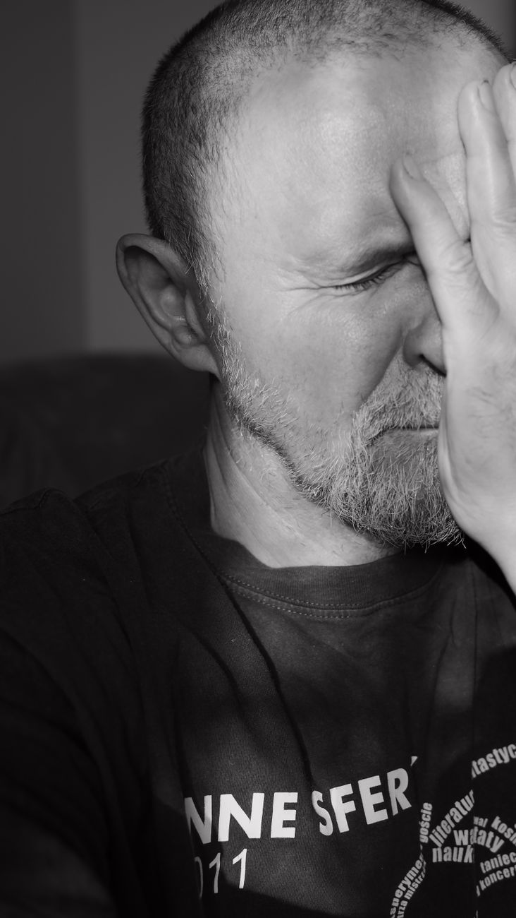 a man with his hands covering his face